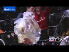 Elderly man struggles to put on poncho at baseball game